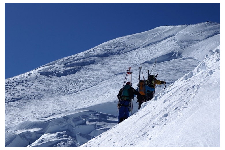 alpinistes avec les skis au dos dans la partie finale de l'ascension au mont blanc, sommet devant eux